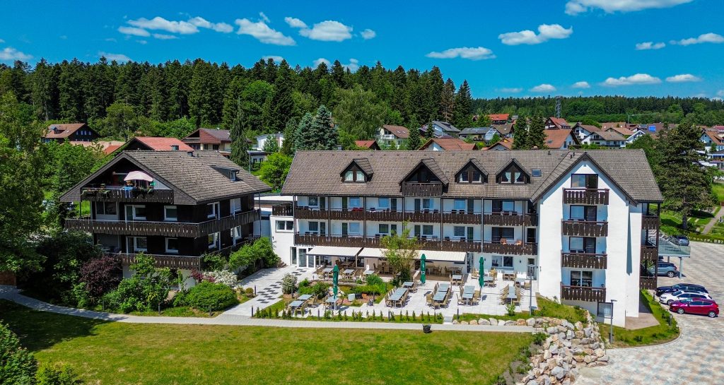 Aerial view of the Wellnesshotel Hohenrodt with the hotel building and the adjacent restaurant terrace, embedded in the natural surroundings of the Black Forest