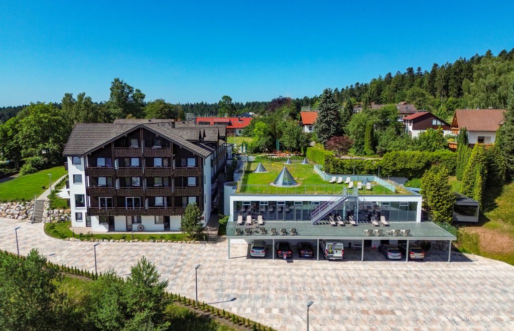 Luftaufnahme des Wellnesshotels Hohenrodt, modernes Hauptgebäude mit lichtdurchflutetem Wellnessanbau inmitten natürlicher Waldlandschaft