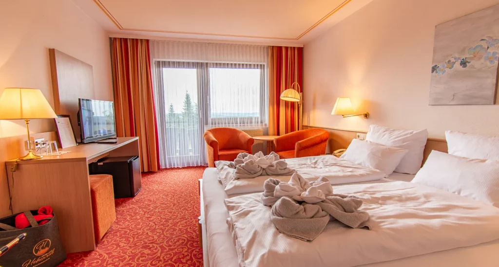 Kinzigtal-Doppelzimmer im Wellnesshotel Hohenrodt mit Doppelbett, Sesseln und hochwertigem Teppichboden