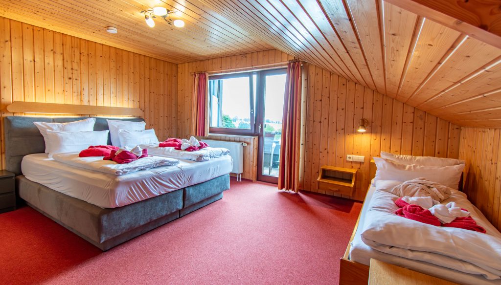 Schlafzimmer des Schwarzwald-Apartments 36 im Wellnesshotel Hohenrodt mit modernem Design und Blick auf die umliegende Natur