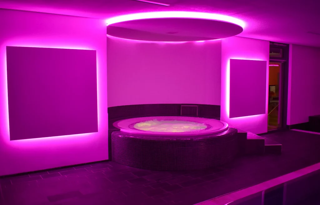Wellnesshotel Hohenrodt, espace piscine bien-être avec bain à remous et éclairage LED violet pour une atmosphère relaxante