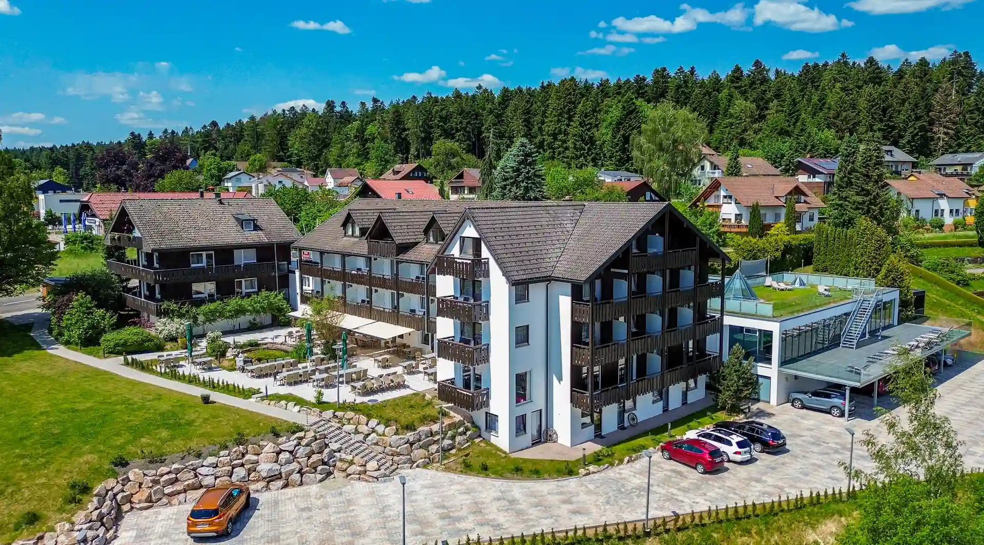 Luftbild des Wellnesshotel Hohenrodt mit Hotelgebäude, Fassade und Parkplatz im Außenbereich