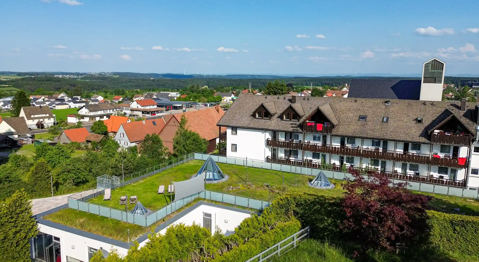 Luftbild des Wellnesshotel Hohenrodt mit Liegewiese und weitem Ausblick auf die Schwäbische Alb