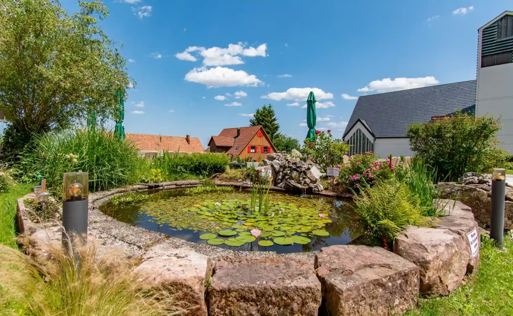 Außenrestaurantterrasse des Wellnesshotel Hohenrodt mit Blick auf einen Teich und Sitzgelegenheiten