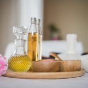 Aroma-Öle in Flaschen mit Massagestempeln und Holzschüsseln mit Salzen für Aromatherapie und Entspannung