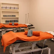 Luxuriöser Massageraum für Partnermassagen mit Doppelbehandlungsliege und sanfter Beleuchtung im Wellnessbereich